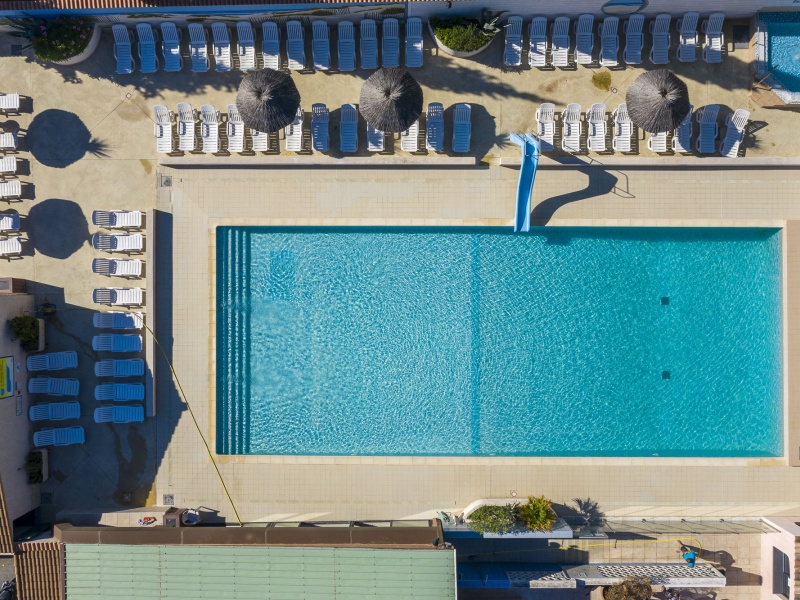 La piscine d'extérieur vue du ciel entourée de nombreux espaces détente